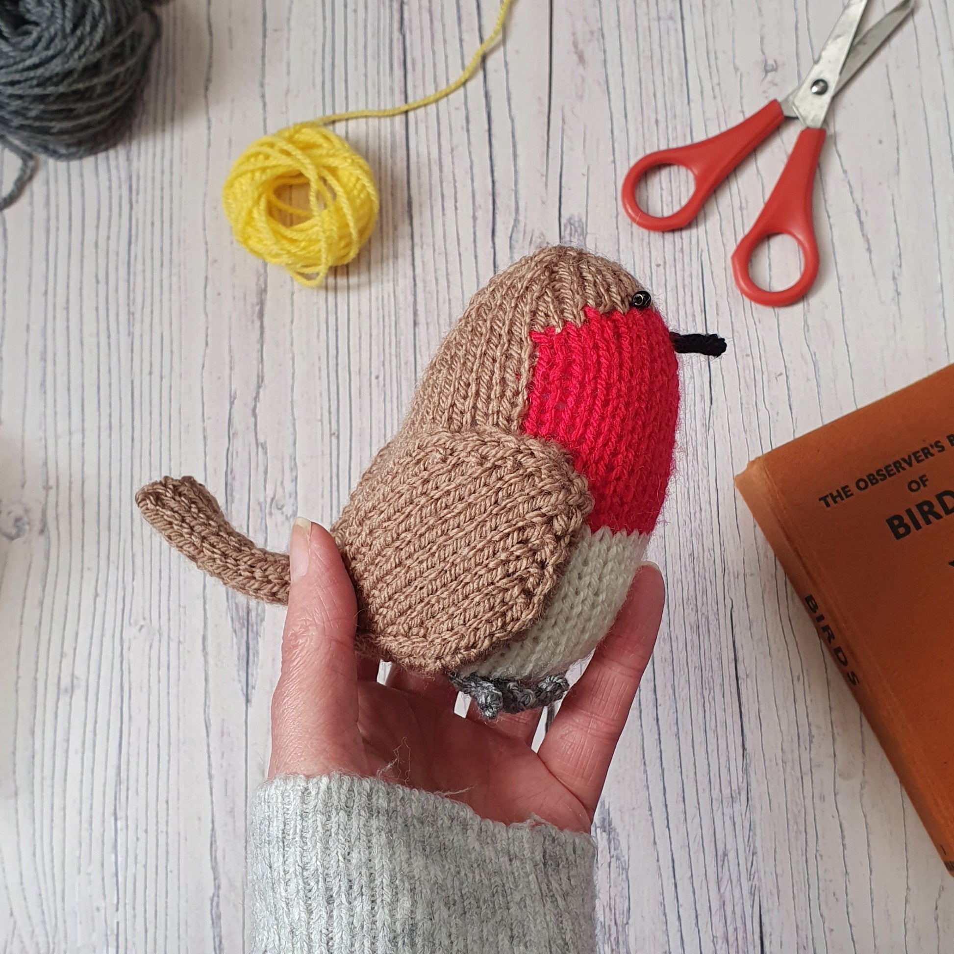 knitted robin with yarn and scissors
