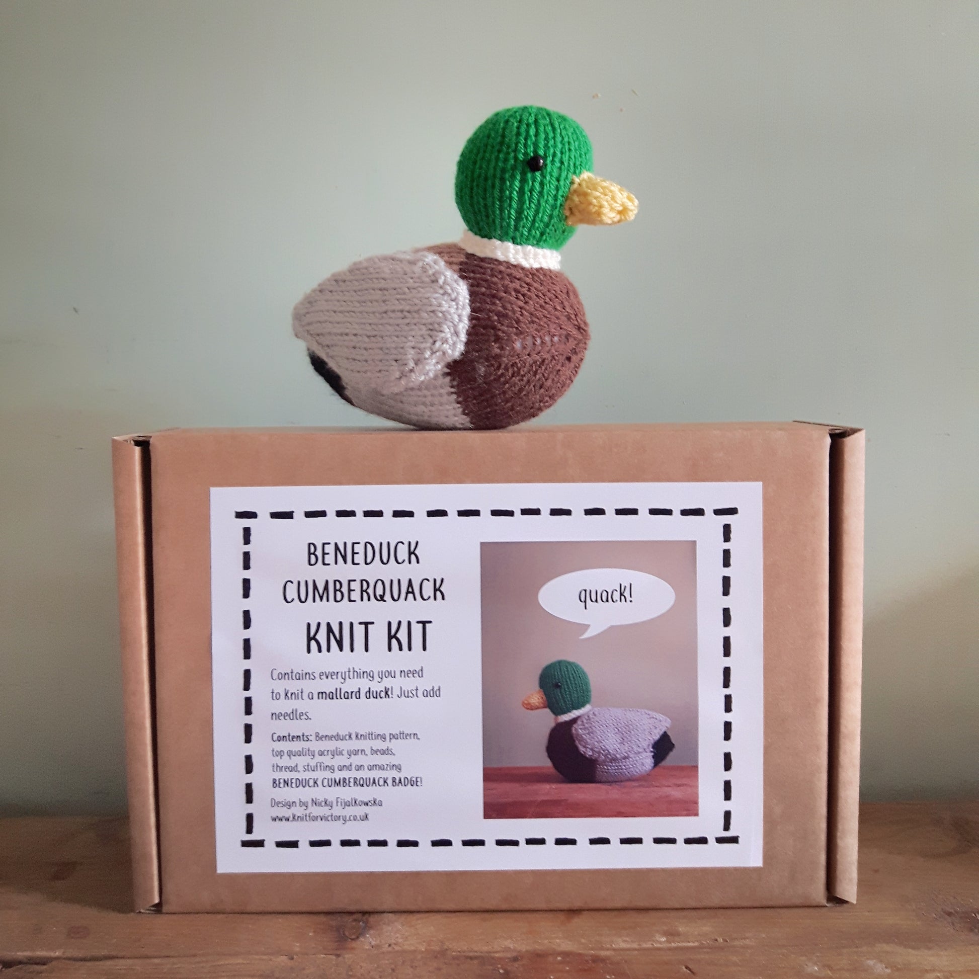 a knitted mallard duck sitting on top of a knitting kit