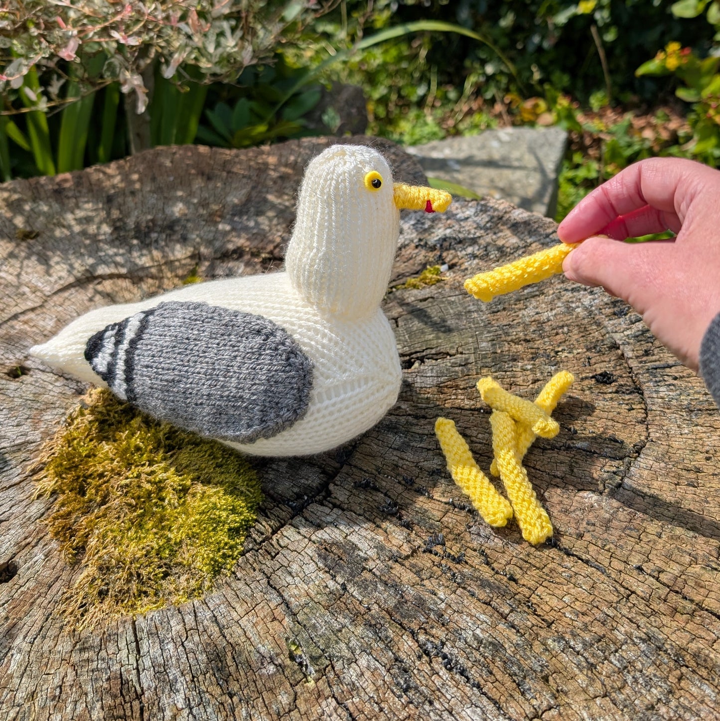 a knitted herring gull being fed knitted chips
